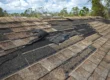 Asphalt roof with shingles peeling off.